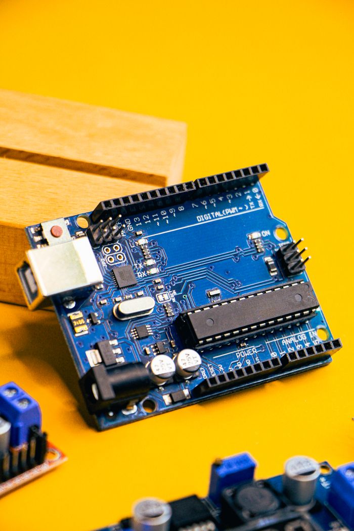 The Art of Drawing Readers In: Your attractive post title goes here Close-up of an Arduino microcontroller on a vibrant yellow background, showcasing electronic innovation.